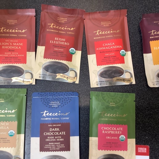 Various packages of Teeccino coffee and tea on a dark surface